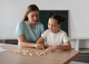 female-psychologist-helping-a-girl-in-speech-therapy